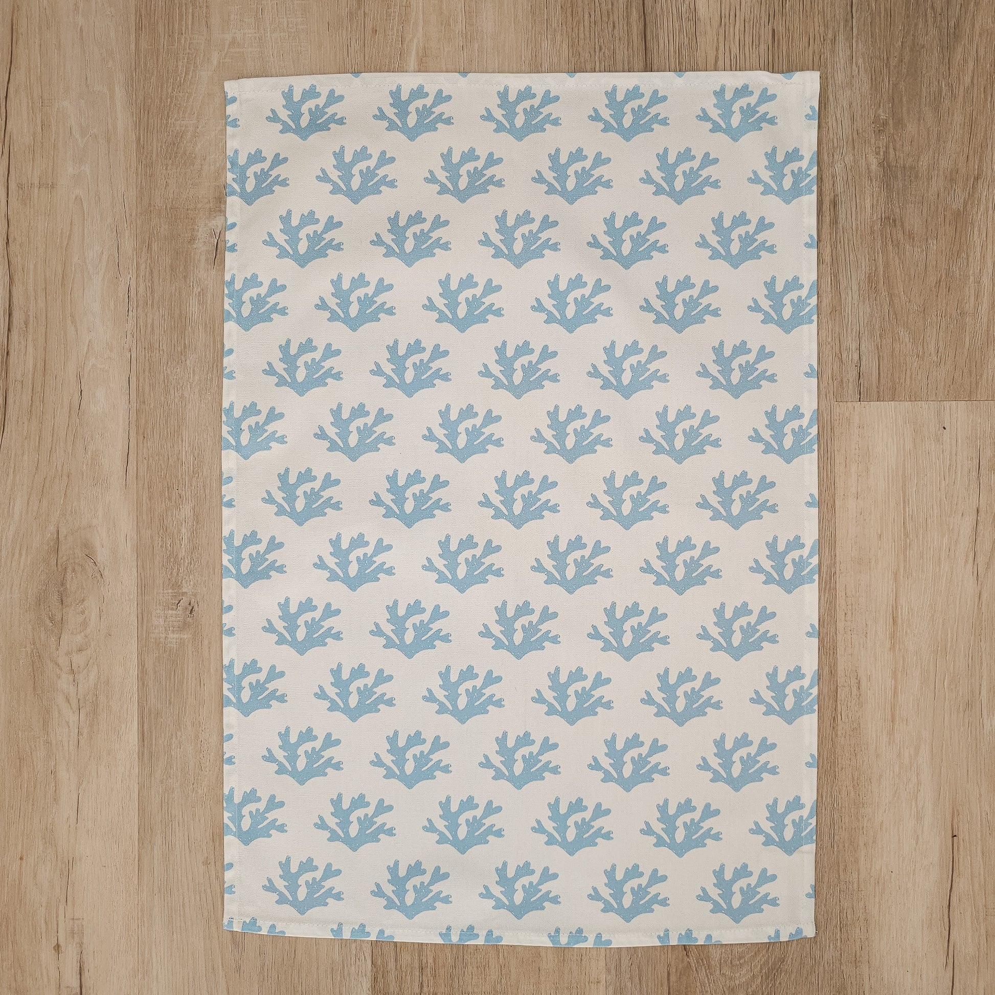 A Seaweed print tea towel from ZIA LIVING arranged flat showing full design on a wooden countertop