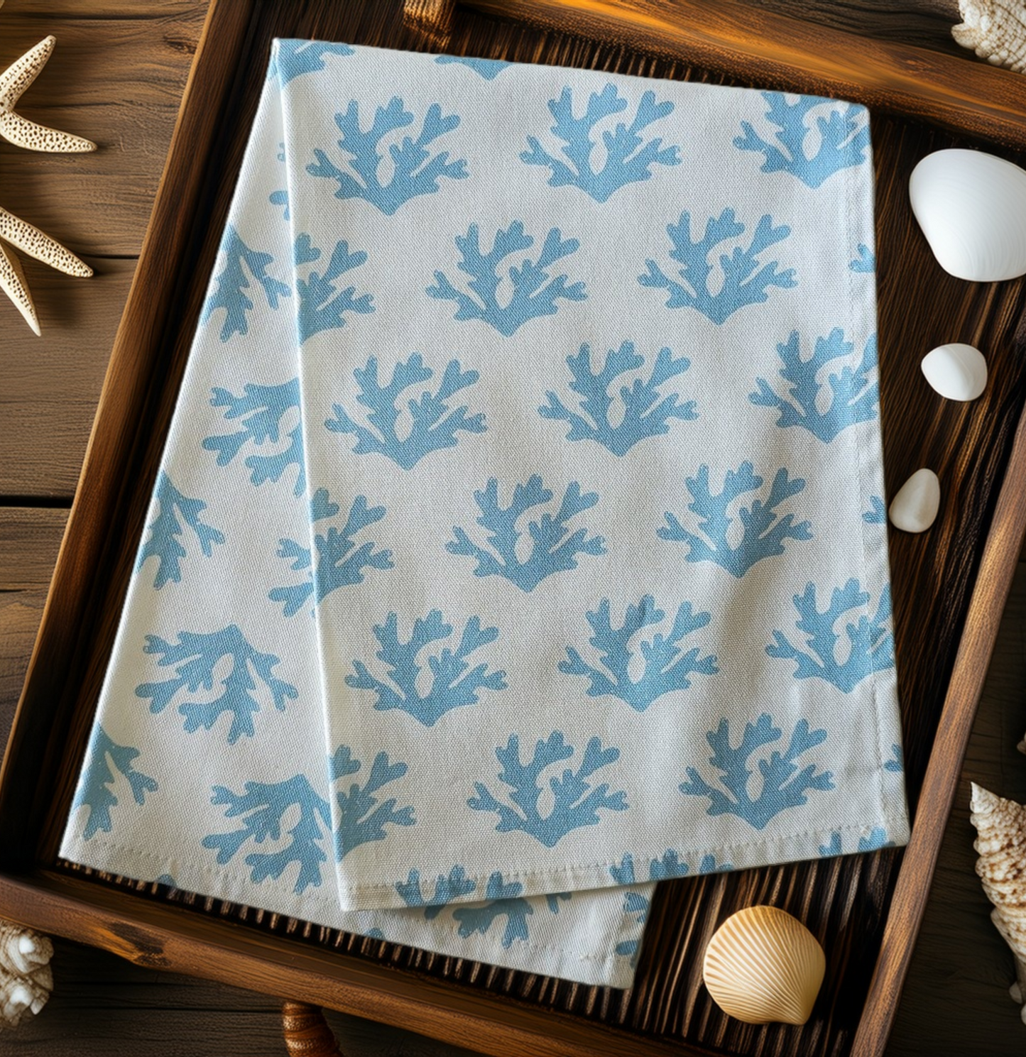 Sky Blue Seaweed patterned tea towel folded in tray with shells, featuring flowing blue seaweed motifs on a light background — ZIA