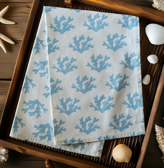 Sky Blue Seaweed patterned tea towel folded in tray with shells, featuring flowing blue seaweed motifs on a light background — ZIA