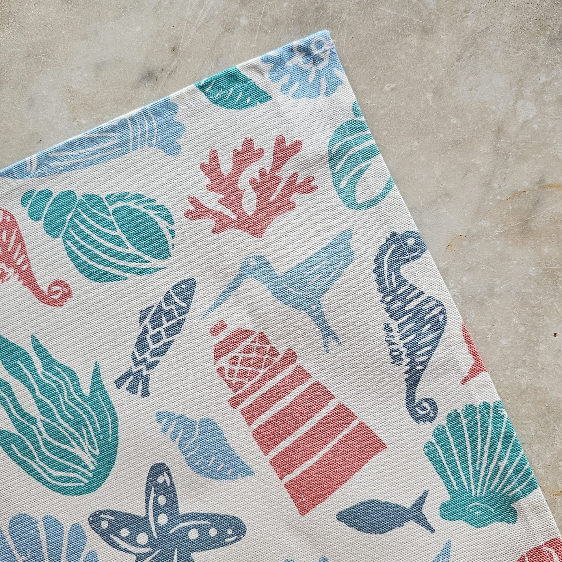 Under the Sea, a colourful coastal sea-themed tea towel close up in blue, coral and teal. Zia Living