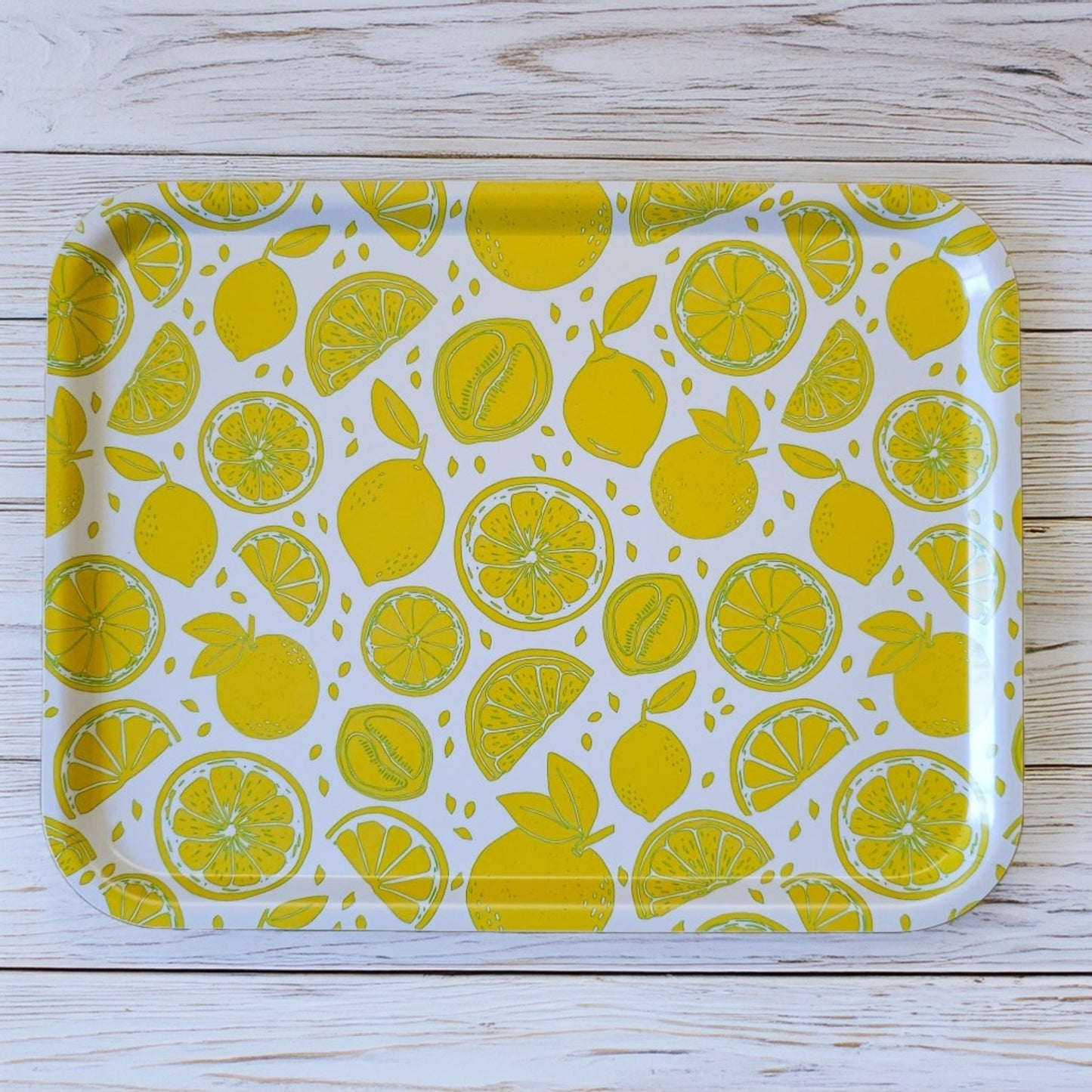 White rectangular tray with a bright yellow lemon and citrus slice pattern, styled on a wooden surface for a fresh, summery kitchen look. ZIA LIVING