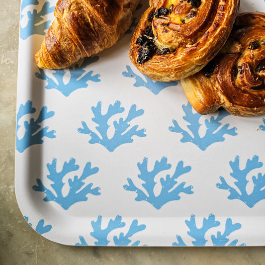 White rectangular tray with a soft blue seaweed coral pattern styled on a wooden surface, finished with a fresh pastries. ZIA LIVING